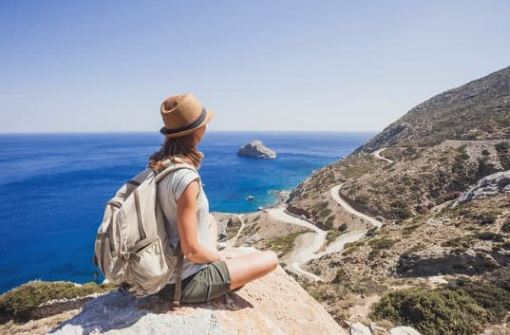 Girl sitting on rock looking at sea